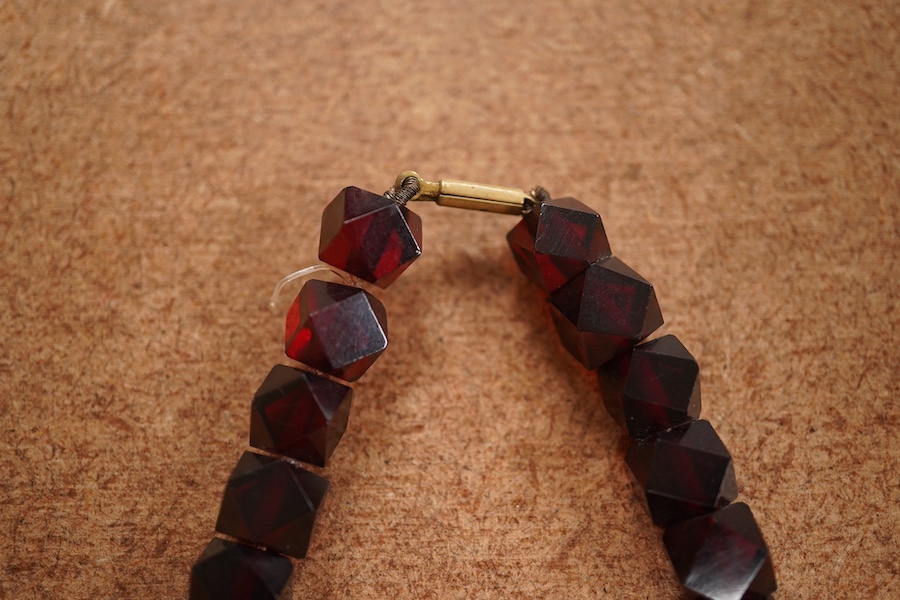 A single strand part facetted simulated cherry amber and part facet paste set necklace, (approx. 30 of the smallest beads are paste), 68cm, gross weight 84 grams. Condition - fair to good